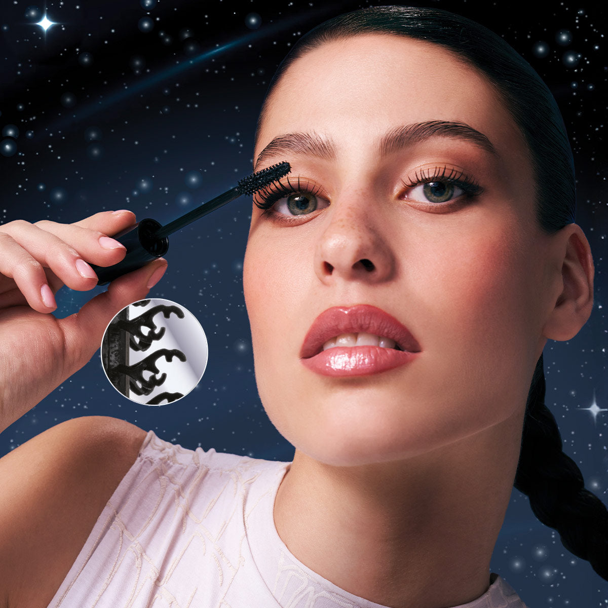 Model, der påfører Cosmic Mascara med tæt billede af børsten